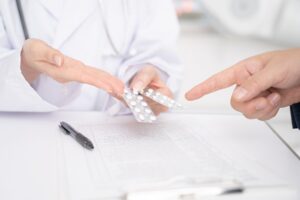 処方箋薬を指さす薬剤師と患者