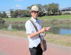 「川辺の緑道で秋の散策を楽しんで」と呼び掛ける若色会長
